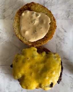 Un primo piano di un hamburger con salsa sopra