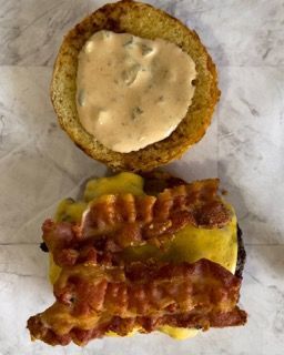 Un primo piano di un hamburger con formaggio e bacon