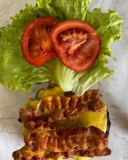 Un primo piano di un panino con lattuga, pomodori e pancetta