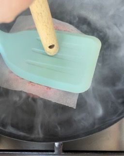 Una persona tiene una spatola sopra una pentola di acqua bollente