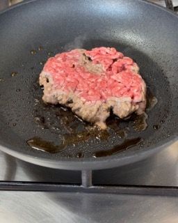 Un pezzo di carne viene cucinato in una padella
