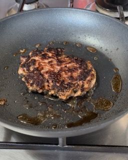 Un pezzo di carne viene cucinato in una padella