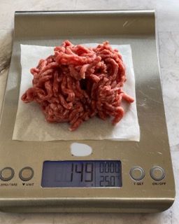 Una bilancia digitale con sopra un mucchio di carne macinata