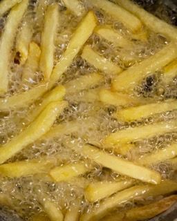 Le patatine fritte vengono cotte in una pentola con olio.