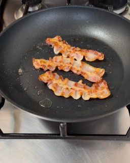 La pancetta viene cotta in una padella sul fornello