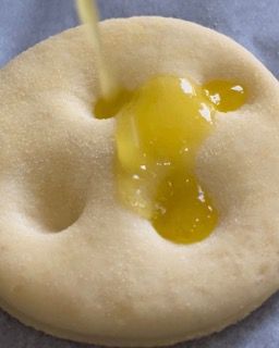 Primo piano di un biscotto su cui viene versato del miele.