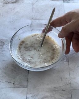 Una persona sta mescolando una ciotola di cibo con un cucchiaio
