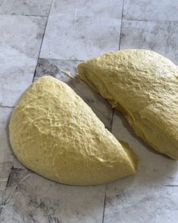 Due pezzi di pasta sono appoggiati su un pavimento piastrellato