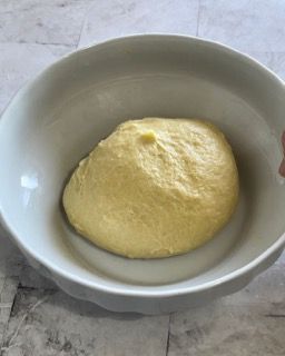 Una ciotola bianca piena di una sostanza gialla su un tavolo.