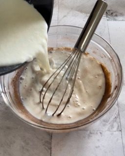 Il latte viene versato in una ciotola con una frusta.