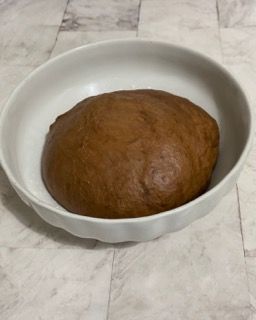 Una ciotola bianca piena di una palla di pasta marrone