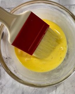 Un pennello è in una ciotola di liquido giallo