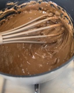 Una ciotola di salsa al cioccolato con una frusta dentro