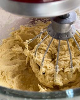 Un mixer sta mescolando un impasto in una ciotola di vetro.