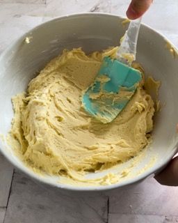 Una persona sta mescolando un impasto in una ciotola con una spatola.