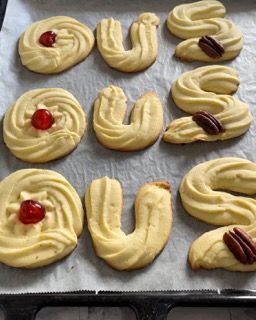 Un vassoio di biscotti con una ciliegia e una noce pecan sopra