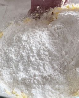 Un primo piano dello zucchero a velo in una ciotola con una spatola.