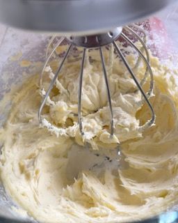 Un mixer sta mescolando il burro in una ciotola di vetro.