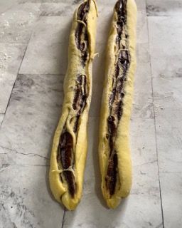 Due pagnotte di pane sono appoggiate su un ripiano di marmo