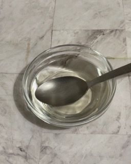 Una ciotola di liquido con un cucchiaio dentro