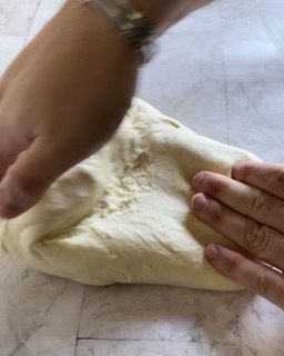 Una persona sta impastando un pezzo di pasta su un tavolo