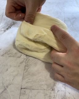 Una persona tiene in mano un pezzo di pasta.