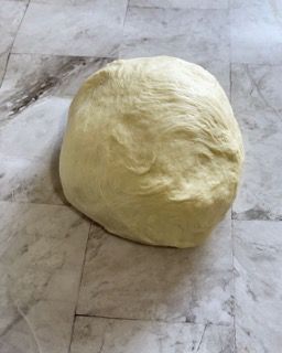 Una palla di pasta è appoggiata su un pavimento piastrellato