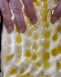 Un primo piano delle mani di una persona su un pezzo di cibo