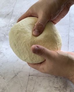 Una persona tiene in mano una palla di pasta