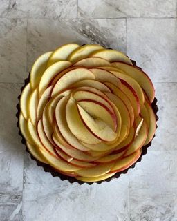 Una torta con fette di mela disposte a forma di fiore