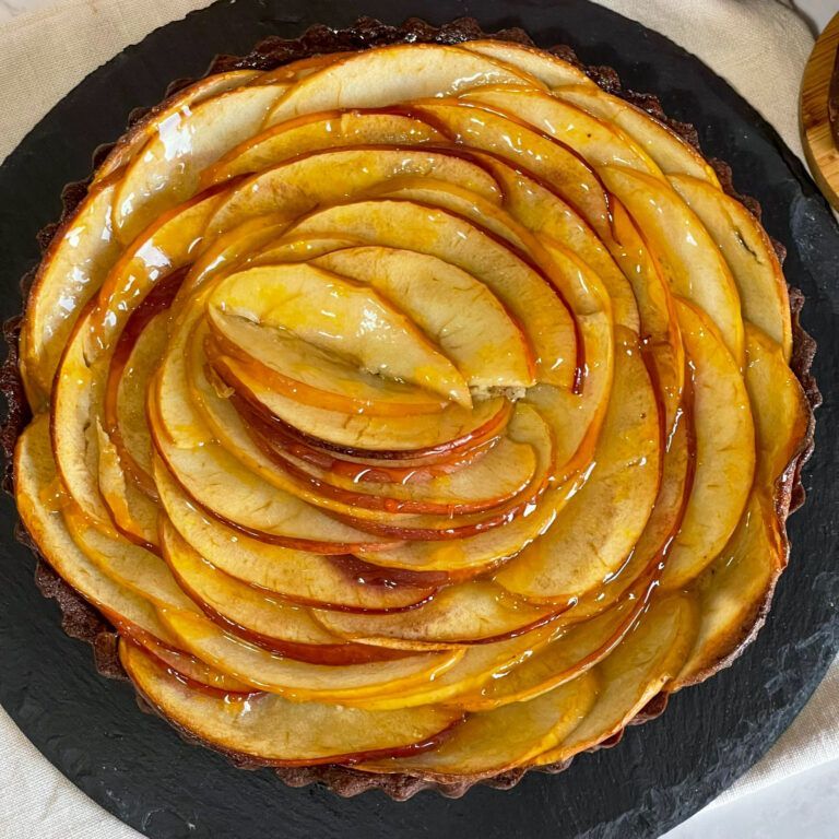 Un primo piano di una torta di mele su un piatto nero