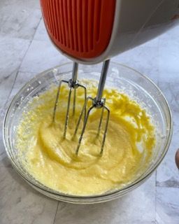 Un mixer sta mescolando un liquido giallo in una ciotola di vetro