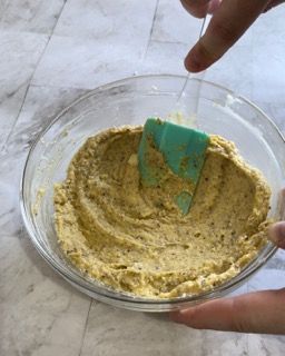 Una persona sta mescolando qualcosa in una ciotola con una spatola