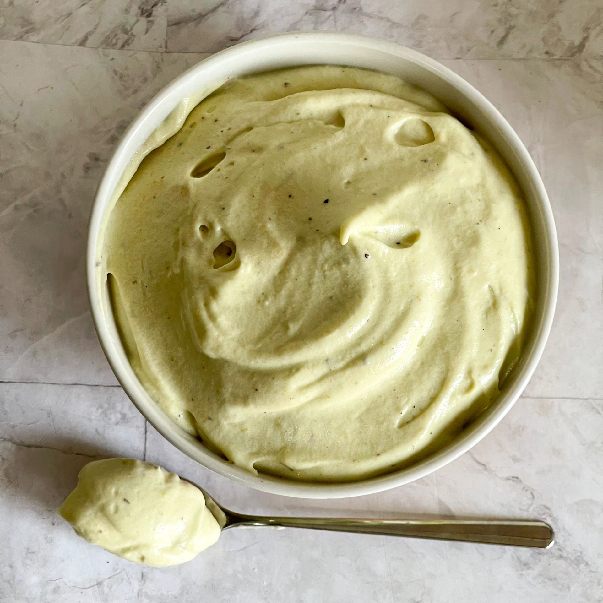 Una ciotola di gelato all'avocado accanto a un cucchiaio