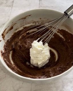 Una ciotola di cioccolato e panna montata con una frusta dentro