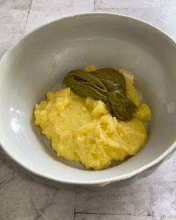 Una ciotola bianca piena di purè di patate e fagiolini