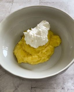 Una ciotola di purè di patate con panna montata sopra.