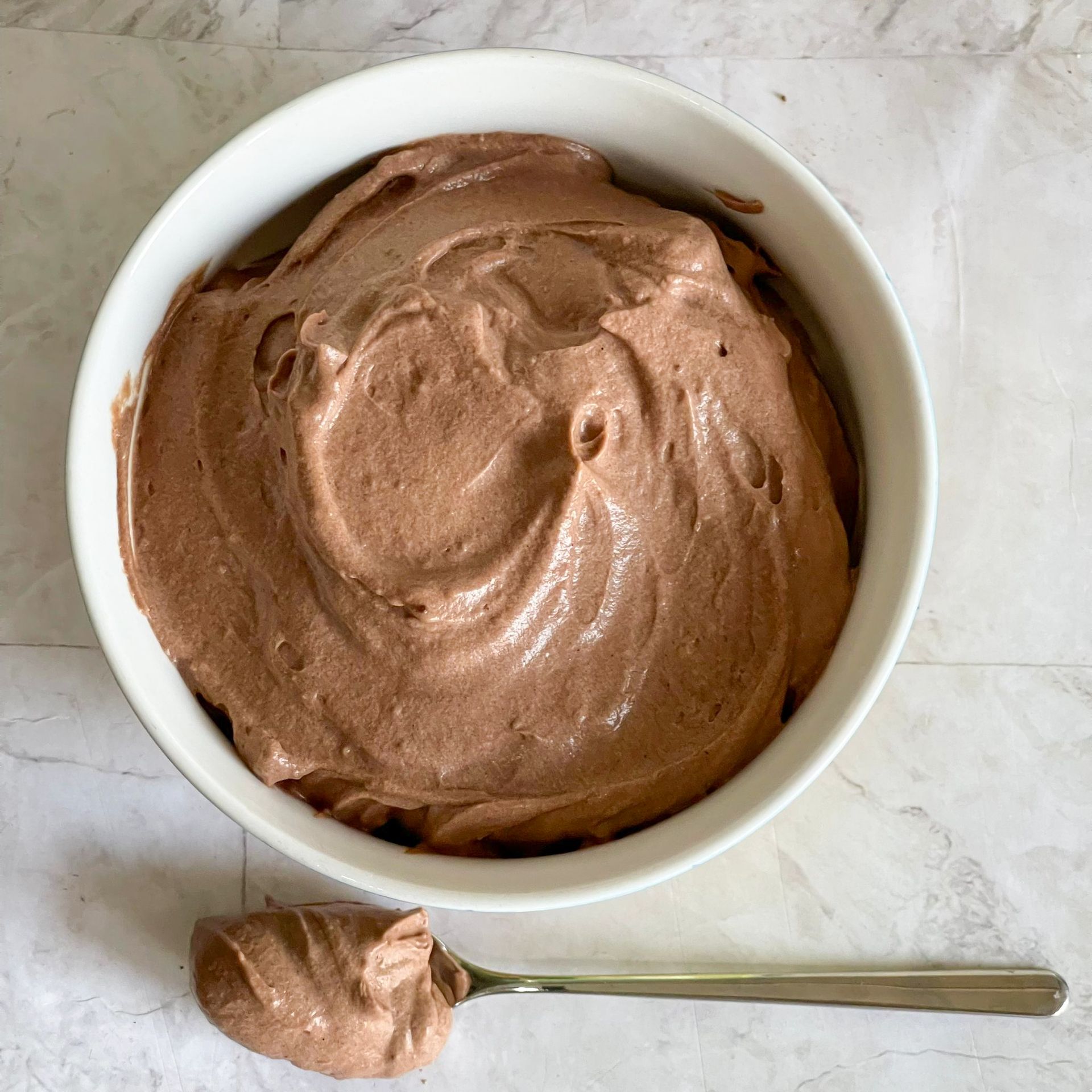 Una ciotola di mousse al cioccolato con un cucchiaio dentro