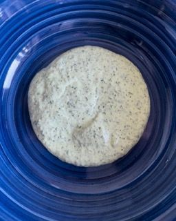 Un piatto blu sormontato da un biscotto ricoperto di salsa.