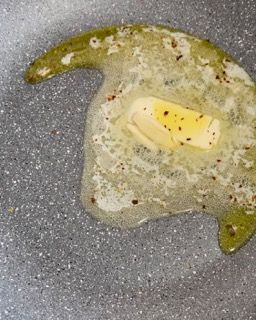 Un pezzo di burro si scioglie in una padella.