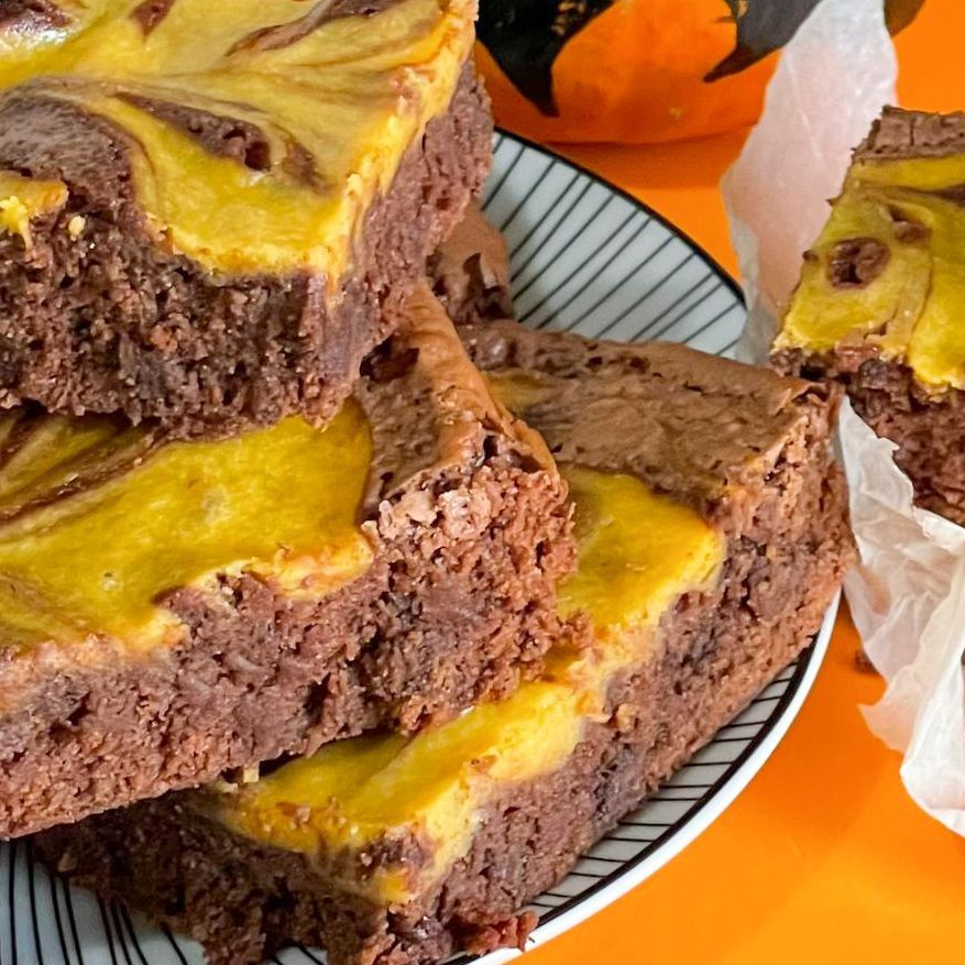 Una pila di brownies con glassa gialla su un piatto