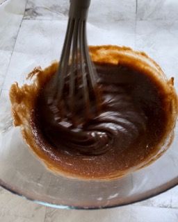Una ciotola di salsa al cioccolato con una frusta dentro