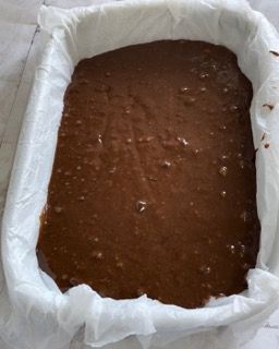 Un impasto per brownie in una padella ricoperta di carta oleata