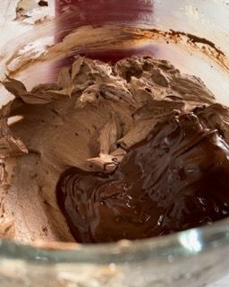 Una ciotola di glassa al cioccolato con una spatola dentro