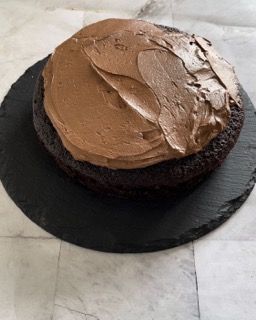 Una torta al cioccolato con glassa al cioccolato su un piatto nero
