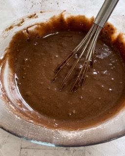 Una ciotola di pastella al cioccolato con una frusta dentro