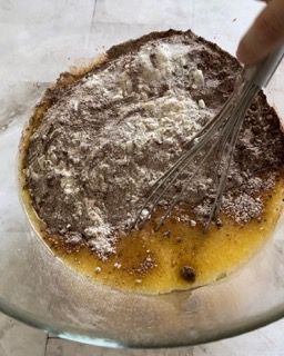 Una persona sta mescolando gli ingredienti in una ciotola con una frusta.