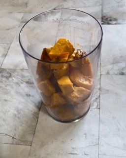 Un bicchiere pieno di pezzi di frutta su un pavimento piastrellato