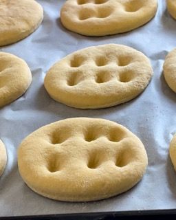 Un mucchio di biscotti sono appoggiati su un foglio di carta oleata