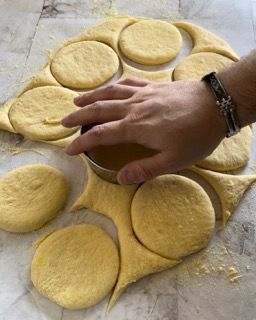 Una persona sta tagliando la pasta in cerchi su un tavolo